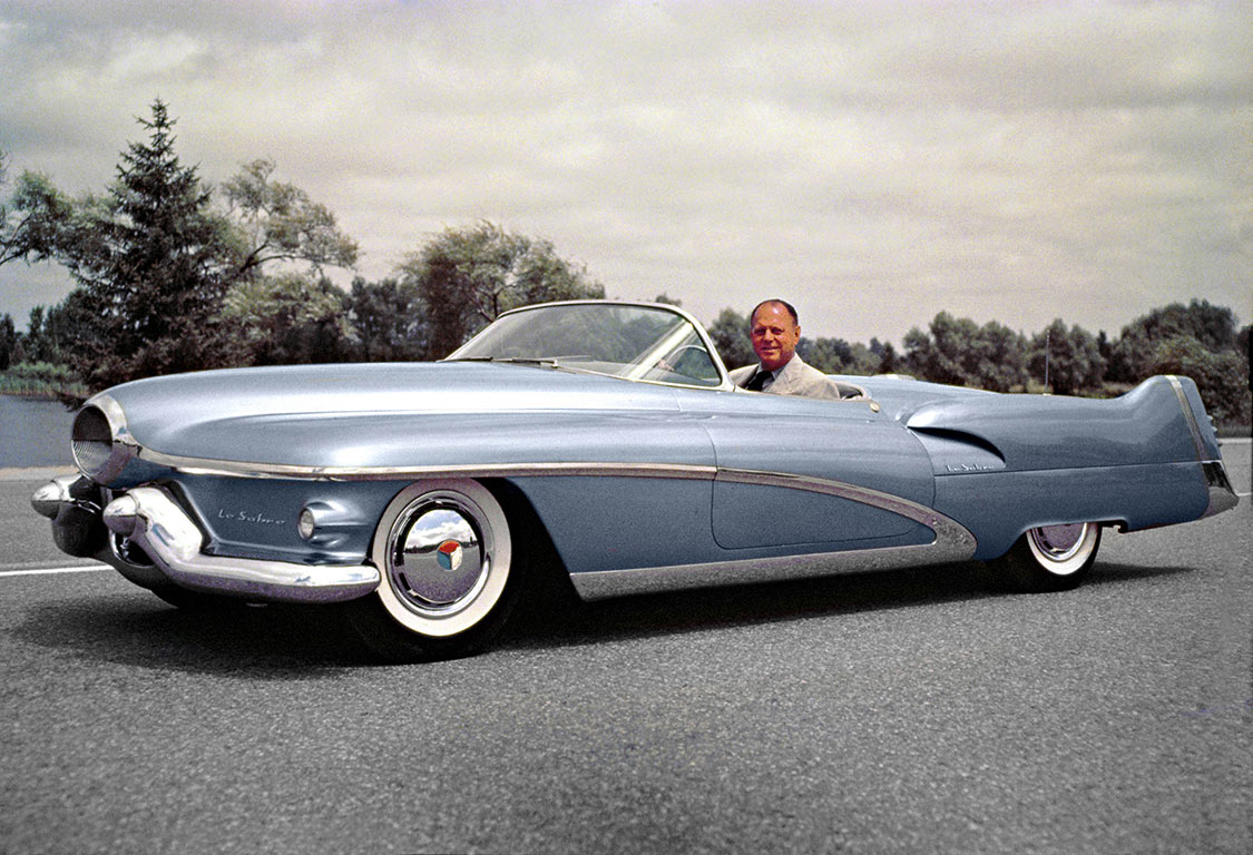 Harley Earl. is sitting in the famous LeSabre concept car