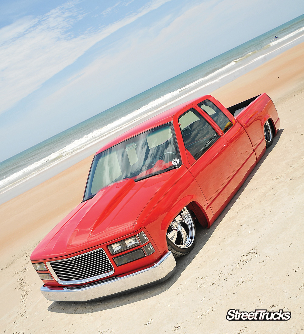 Red 1994 Chevrolet on the beach